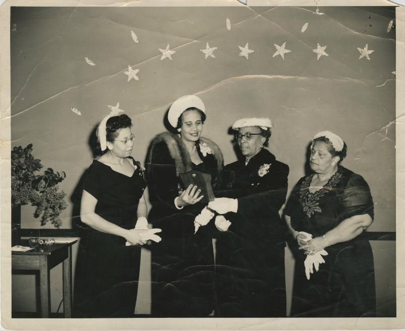 Black and white photograph of Lucille Poinsette, Ruby Cornwell, Septima P. Clark, E. B. Burroughs at the Alpha Kappa Alpha sorority testimonial dinner for Clark. 1956. 
