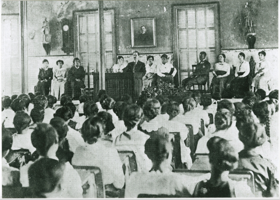 Photograph of Principal Cox addressing student body in weekly chapel service in the Avery auditorium, 1916.